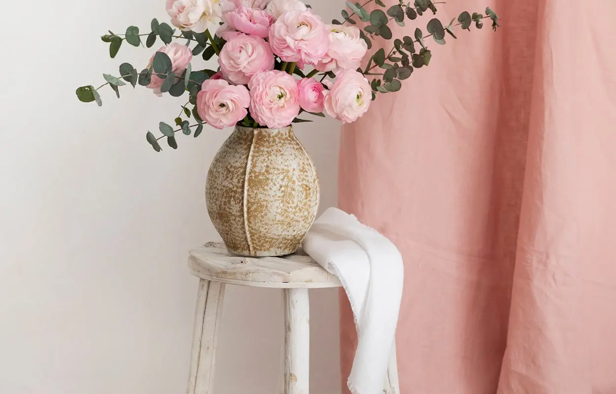 Vase mit rosa Blumen auf rustikalen weißen Hocker im Shabby Chic Stil bei Möbel Schuh